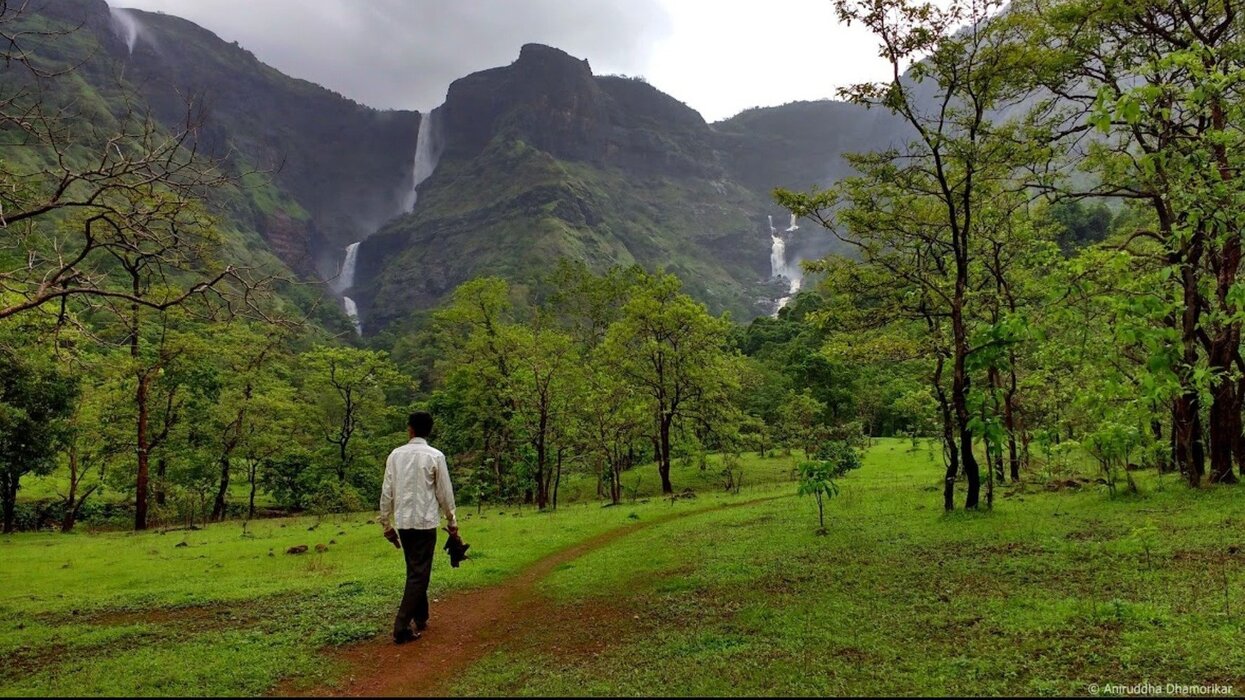 Man trekking through green forest to Kalu Waterfall
