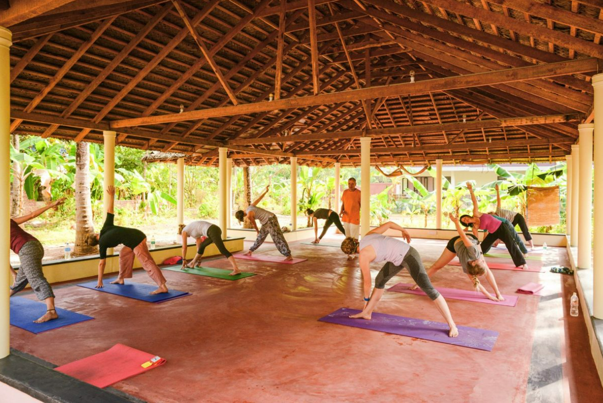 People practicing yoga in a gazebo at Sharangati Yoga Retreat in Kerala