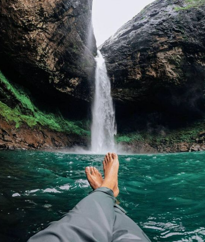 Tourist sitting by gushing Devkund Waterfall after trek